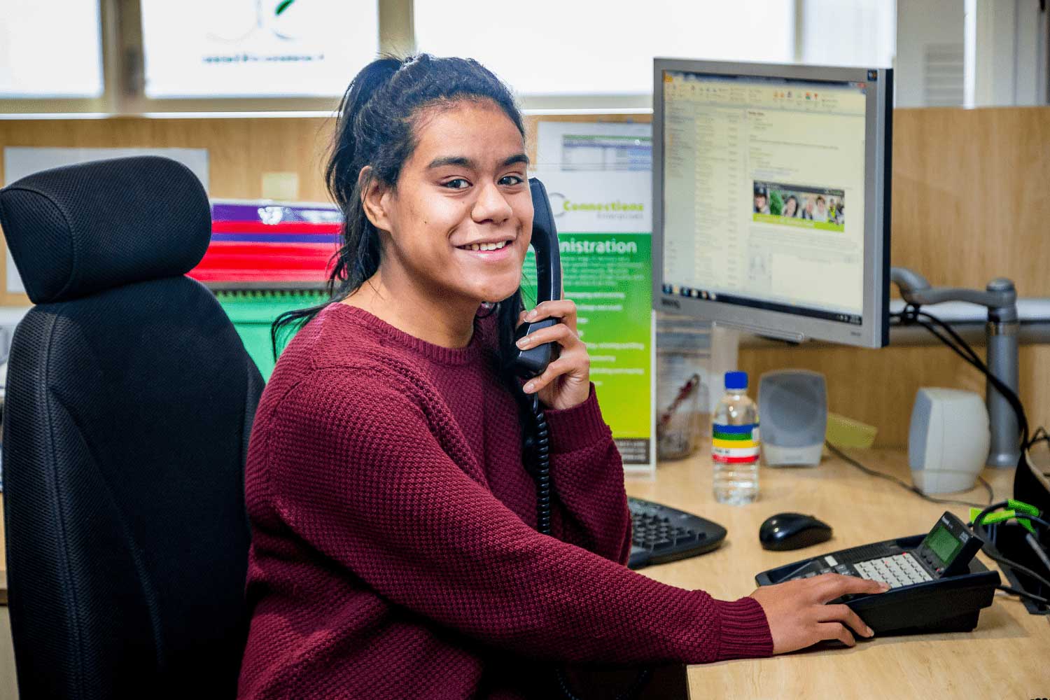 Young Women Smiling While Answering Phone Call Through OC Connections Supported Employment Program