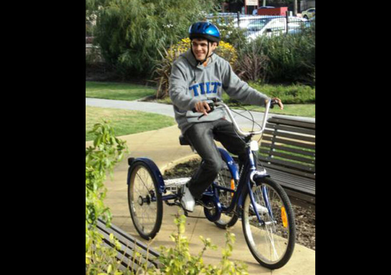 young male participant riding an accessible friendly bike