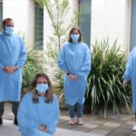 Staff from Insurance Australia Group wearing gowns and masks at OCC Enterprises during stage 4 lockdown